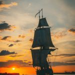 silhouette of ship on sea during sunset