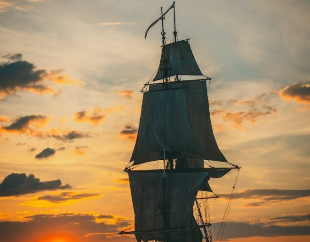 silhouette of ship on sea during sunset