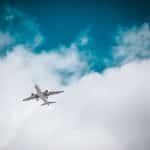 white airplane under blue sky and white clouds during daytime