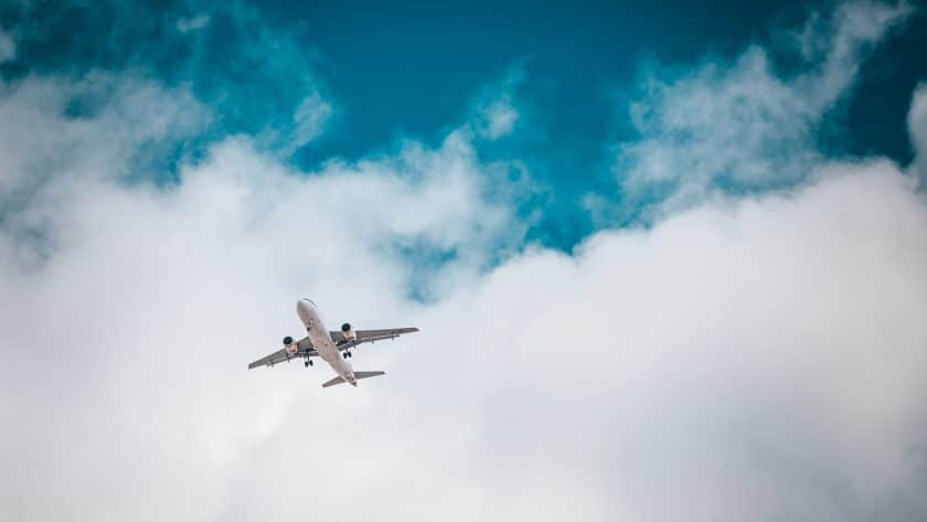 white airplane under blue sky and white clouds during daytime